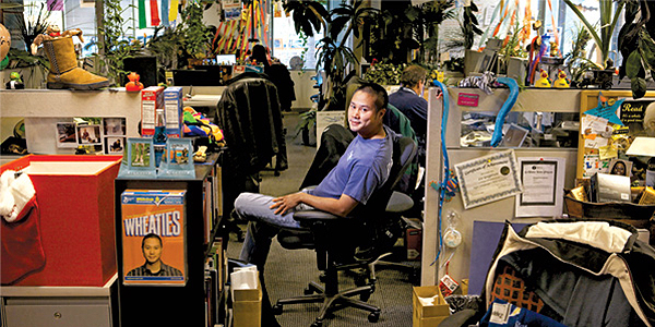 cluttered customer service office with man sitting in chair with head turned toward camera